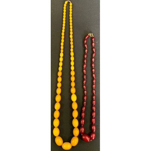 302 - A Cherry amber coloured graduated bead necklace, from 25mm x 17mm ton , 13mm x 7mm, 35.4g, 58cm long... 