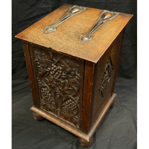 277 - An Arts and Crafts oak slope top coal  bin/purdonium, teh front carved with scrolling vine, copper h... 