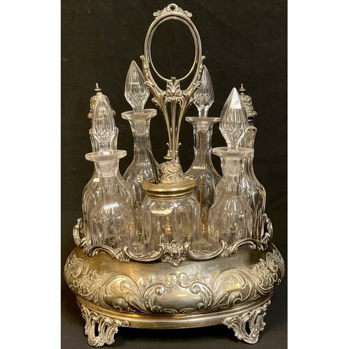 66 - A Victorian silver plated seven bottle cruet stand, embossed with foliate scrolls, original bottles ... 