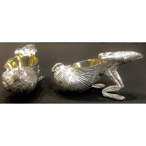 90 - A pair of novelty silver plated table salts modelled as frogs pulling shells, 10cm wide