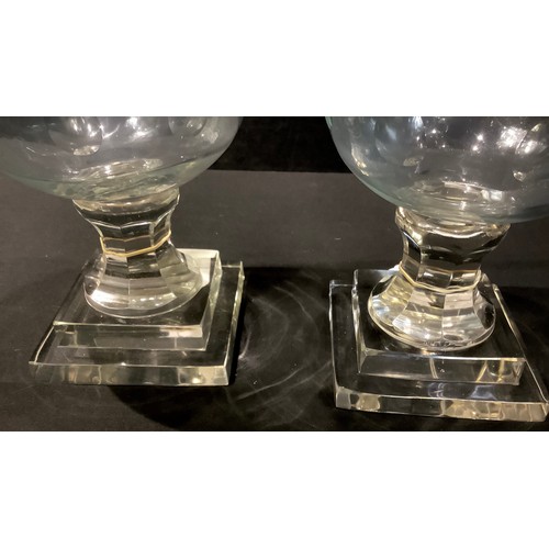 123 - A large pair of reproduction Victorian style glass storm lamps, stepped bases, approx. 40cm high