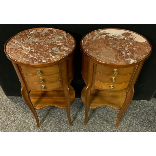 230 - A pair of French mahogany oval bedside tables / cabinets, rouge marble tops, three small drawers to ... 