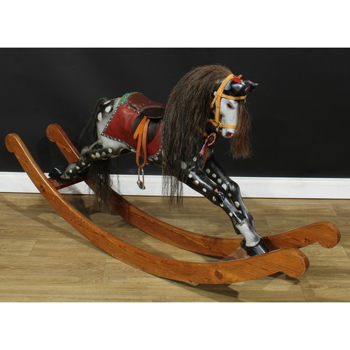 4040 - A 20th century rocking horse on a bow rocker, the carved and later over-painted/re-painted dappled h... 