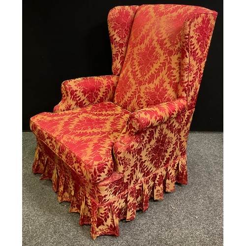 235A - A wingback arm chair, upholstered in red and gold floral fabric, sprung base, plain legs; 106cm x 57... 