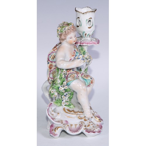 690 - A Derby patch mark figural candlestick, modelled as Cupid kneeling before bocage, scroll and shell b... 