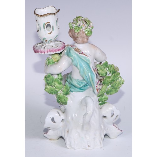 690 - A Derby patch mark figural candlestick, modelled as Cupid kneeling before bocage, scroll and shell b... 