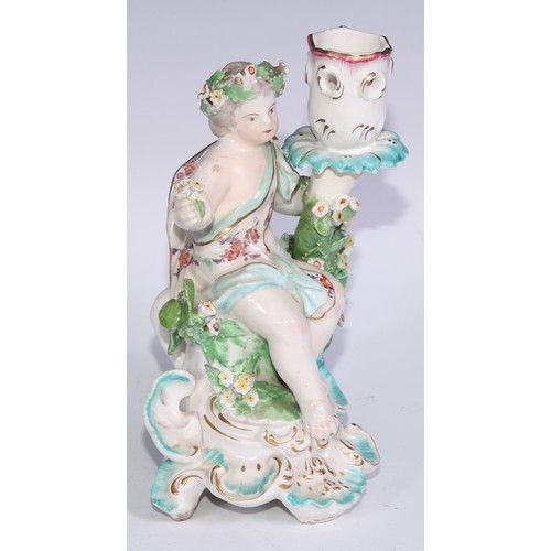 690 - A Derby patch mark figural candlestick, modelled as Cupid kneeling before bocage, scroll and shell b... 