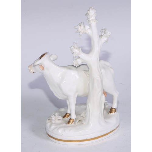 666 - A Bloor Derby model, of a cow, modelled standing beside a tree, in the white, picked out in flesh to... 