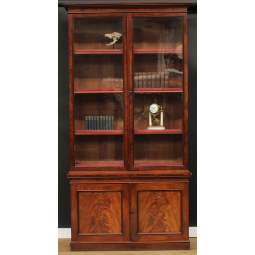 345 - A 19th century mahogany library bookcase, outswept cornice above a pair of glazed doors enclosing ad... 