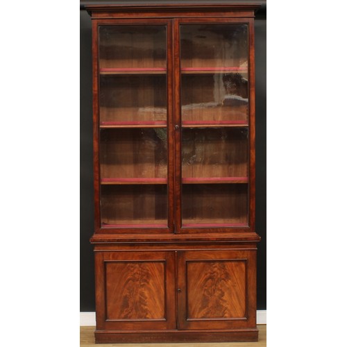 345 - A 19th century mahogany library bookcase, outswept cornice above a pair of glazed doors enclosing ad... 