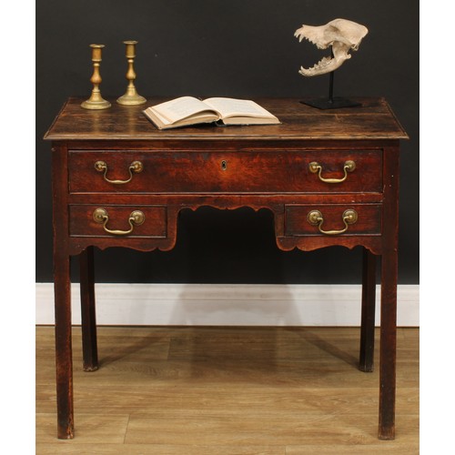 423 - A George III oak lowboy, rectangular top above three drawers, shaped apron, internally chamfered leg... 