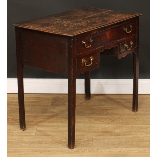 423 - A George III oak lowboy, rectangular top above three drawers, shaped apron, internally chamfered leg... 