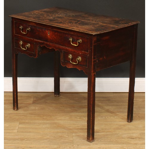 423 - A George III oak lowboy, rectangular top above three drawers, shaped apron, internally chamfered leg... 