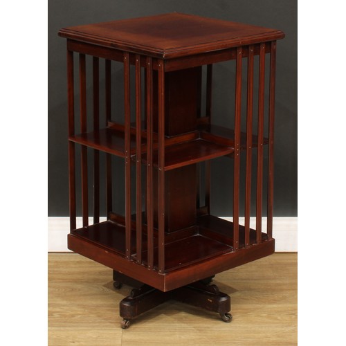 515 - An Edwardian mahogany revolving bookcase, square top with moulded edge above an arrangement of shelv... 