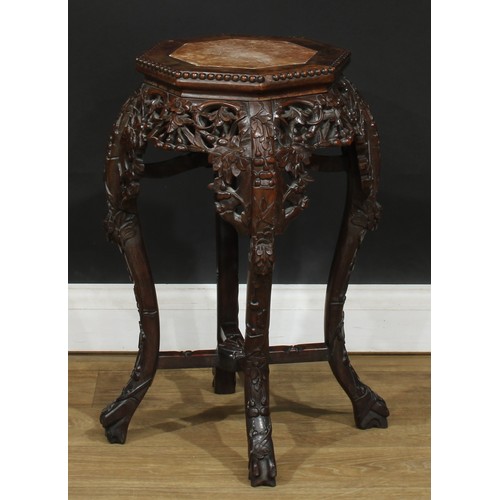 351 - A Chinese hardwood jardiniere stand, octagonal top with inset soapstone panel above a shaped and pie... 