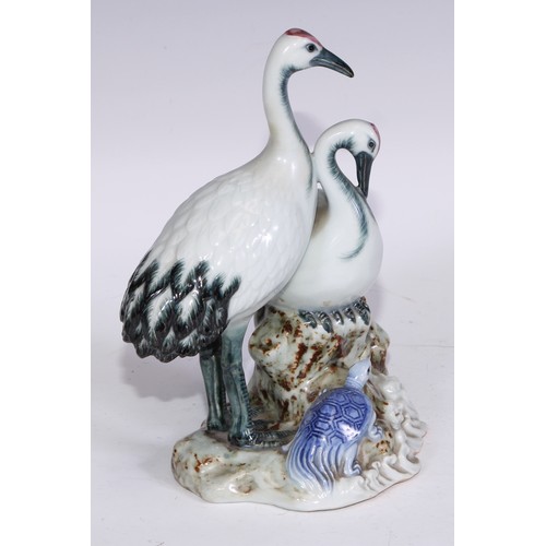 728 - A Continental porcelain model, of a parrot, perched upon an oak tree stump, coloured in tones of gre... 