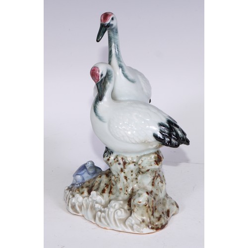 728 - A Continental porcelain model, of a parrot, perched upon an oak tree stump, coloured in tones of gre... 