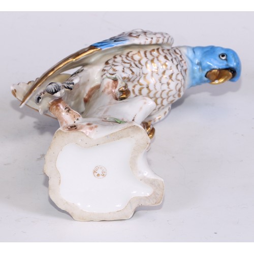 728 - A Continental porcelain model, of a parrot, perched upon an oak tree stump, coloured in tones of gre... 