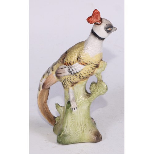 728 - A Continental porcelain model, of a parrot, perched upon an oak tree stump, coloured in tones of gre... 