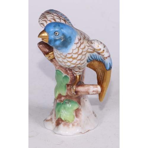 728 - A Continental porcelain model, of a parrot, perched upon an oak tree stump, coloured in tones of gre... 