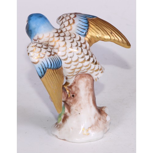 728 - A Continental porcelain model, of a parrot, perched upon an oak tree stump, coloured in tones of gre... 