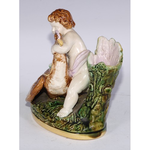 736 - A Majolica figural spill vase, modelled as a putto with a bird, 15.5cm wide; a pair of Staffordshire... 