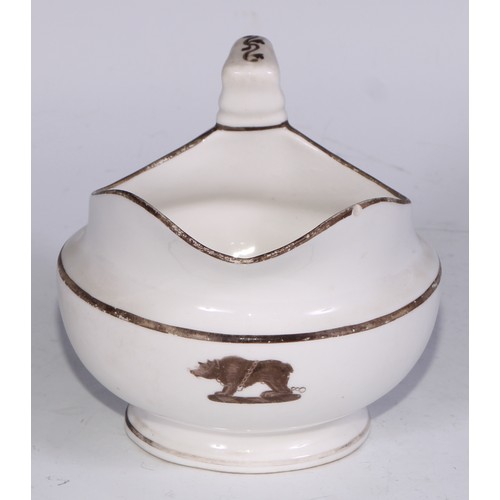 669 - A Derby armorial helmet shaped cream jug, printed in monochrome with a heraldic crest, 15cm long, c.... 