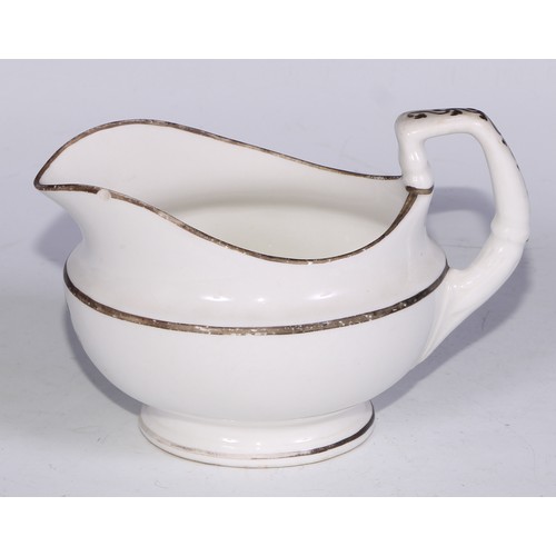 669 - A Derby armorial helmet shaped cream jug, printed in monochrome with a heraldic crest, 15cm long, c.... 