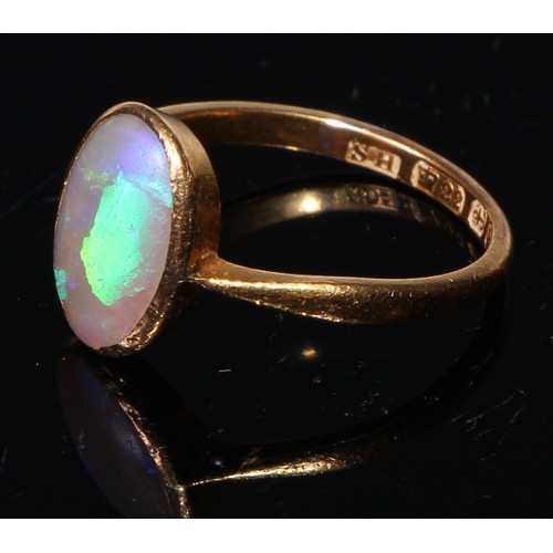 138 - A 22ct gold and opal ring, the oval cabochon stone bezel set, plain shank, size M/N, 3.1g gross