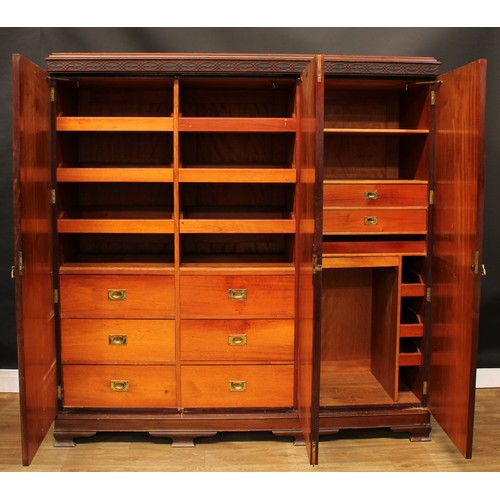 502 - An early 20th century mahogany wardrobe, blind fretwork cornice above three doors, fitted with linen... 