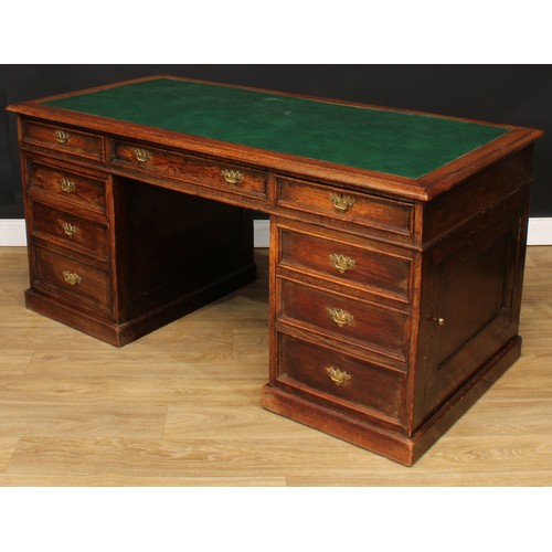 522 - An oak twin pedestal desk, rectangular top with inset writing surface above three frieze drawers, on... 