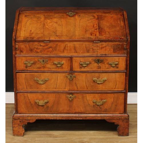 355 - A George II feather-banded walnut bureau, crossbanded fall front enclosing a well with secret compar... 