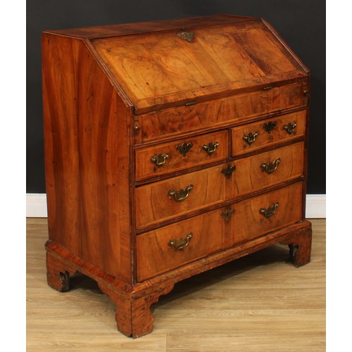 355 - A George II feather-banded walnut bureau, crossbanded fall front enclosing a well with secret compar... 