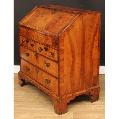 355 - A George II feather-banded walnut bureau, crossbanded fall front enclosing a well with secret compar... 