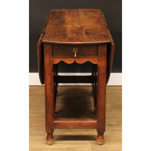 496 - An 18th century oak double-gateleg table, oval top with fall leaves above a single frieze drawer, ch... 