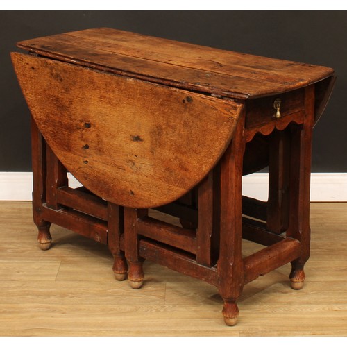 496 - An 18th century oak double-gateleg table, oval top with fall leaves above a single frieze drawer, ch... 