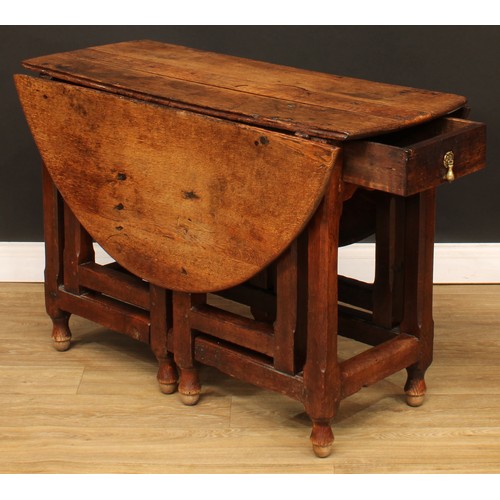 496 - An 18th century oak double-gateleg table, oval top with fall leaves above a single frieze drawer, ch... 