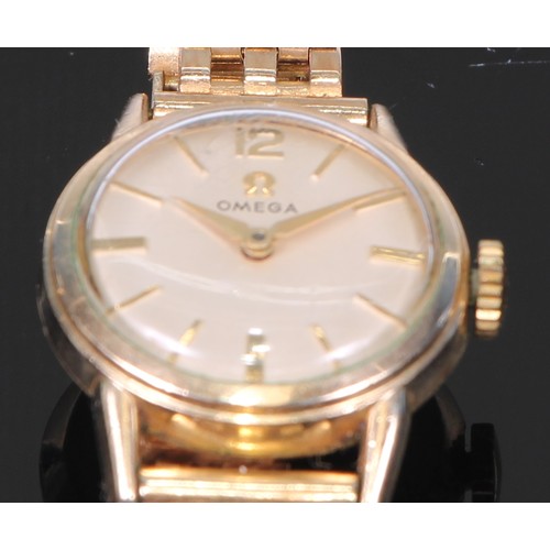 64 - A 9ct gold Omega lady's wristwatch, 1.75cm champagne dial with baton markers and Arabic numeral 12, ... 