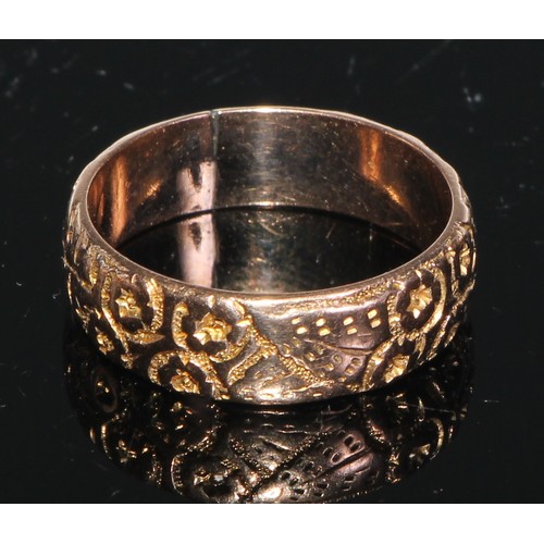 152 - A 9ct gold wedding band, engraved and chased with foliate scrolls; a 9ct gold buckle ring; a 9ct gol... 