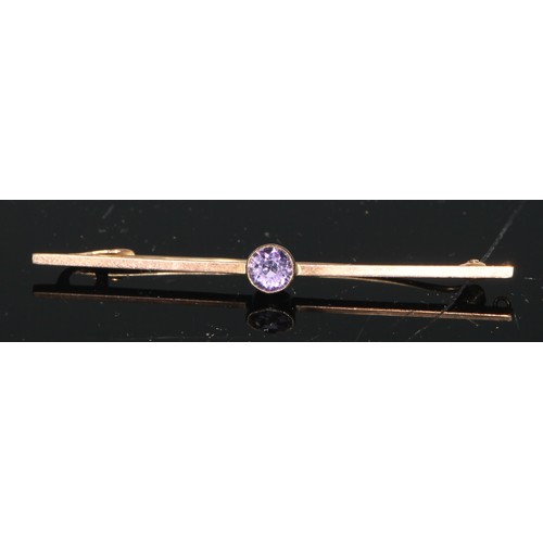 139 - A 9ct gold and amethyst bar brooch, the central oval faceted stone flanked by seed pearls, 5.5cm wid... 