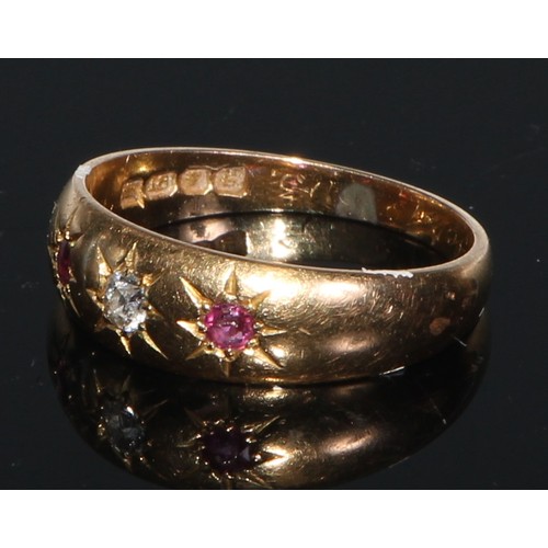 244 - An 18ct gold ring, set with three rubies divided by four small diamonds, engraved with scrolls to sh... 