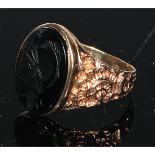 179 - A gentleman's seal ring, the curved rectangular tigers eye tablet engraved with a intaglio after the... 