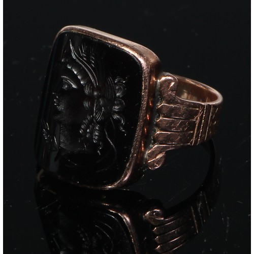 179 - A gentleman's seal ring, the curved rectangular tigers eye tablet engraved with a intaglio after the... 