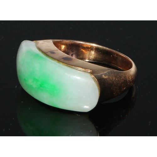 106 - A 14ct gold and jadeite ring, set with an oversized curved rectangular panel, the mount and shoulder... 