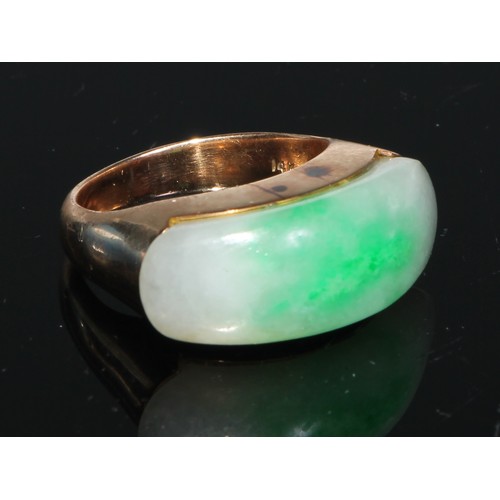 106 - A 14ct gold and jadeite ring, set with an oversized curved rectangular panel, the mount and shoulder... 