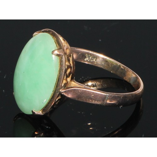 106 - A 14ct gold and jadeite ring, set with an oversized curved rectangular panel, the mount and shoulder... 