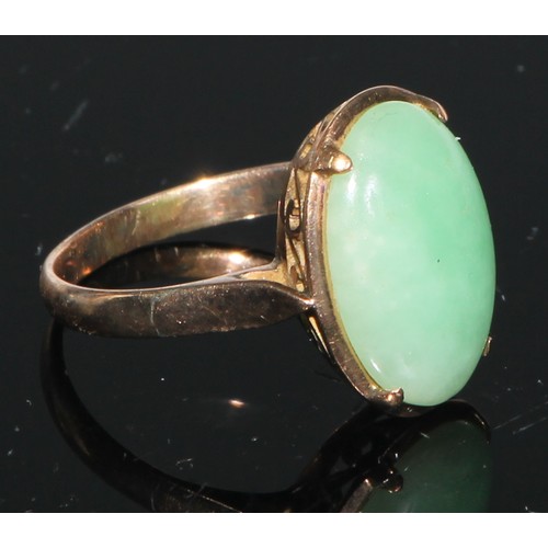 106 - A 14ct gold and jadeite ring, set with an oversized curved rectangular panel, the mount and shoulder... 