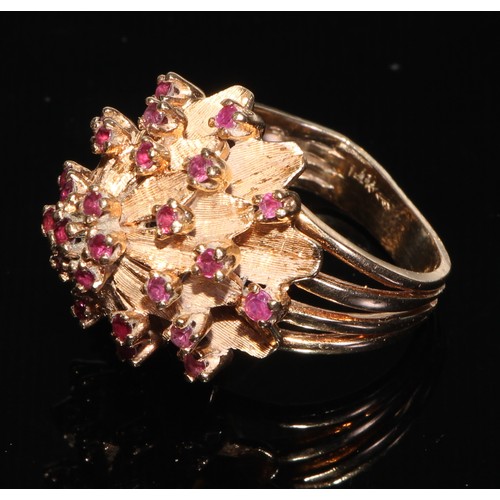 188 - A large gold coloured metal flowerhead cluster ring, each petal divided by a small brilliant spinel,... 