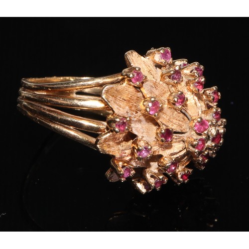 188 - A large gold coloured metal flowerhead cluster ring, each petal divided by a small brilliant spinel,... 