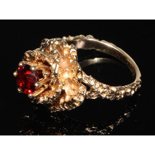 188 - A large gold coloured metal flowerhead cluster ring, each petal divided by a small brilliant spinel,... 